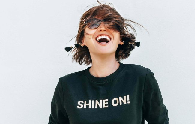 Free feeling happy woman posing in black sweatshirt with positiv